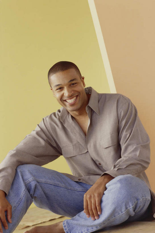 西方人,一个人,坐,笑,盘腿,微笑,露齿笑,竖图,室内,白天,正面,欧洲,非洲,黑人,欧洲人,仅一个男性,仅一个人,仅一个中年男性,阴影,服装,裤子,反射,影子,注视,牛仔裤,休闲装,漂亮,衣服,观察,看,休闲,休闲服,搭,摄影,服饰,影棚,观看,察看,搭着,关注,男人,男性,中年男性,非洲人,盘腿而坐,盘膝,盘着腿的,盘着腿坐,双腿交叉,坐着,半身,彩图,影棚拍摄,拍摄,俊秀,英俊