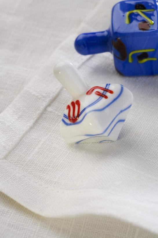 无人,竖图,俯视,室内,特写,白天,游戏,静物,节日,庆祝,玩,文化,娱乐,两个,蓝色,白色,陀螺,祈祷,庆典,休闲,健康,益智,许愿,摄影,宗教,信仰,影棚,活动,纪念,祈求,发泄,消遣,智力,犹太教,光明节,宣泄,陀罗,干乐,冰尜,打老牛,独乐,挑筋教,平安,玩耍,嬉戏,彩图,高角度拍摄,影棚拍摄,拍摄