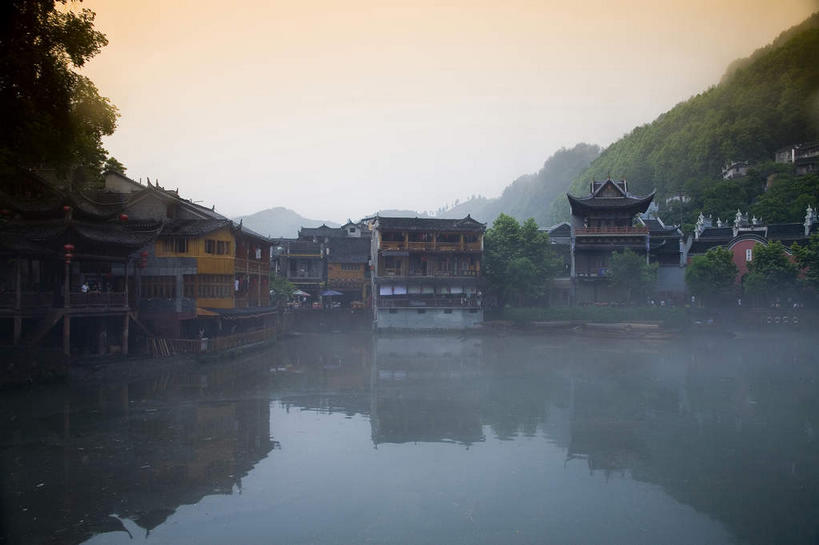 无人,家,横图,室外,白天,正面,旅游,度假,河流,名胜古迹,日落,山,山脉,水,植物,雾,标志建筑,地标,建筑,中国,亚洲,朦胧,模糊,遗迹,凤凰,房屋,屋子,河水,山峰,水流,晚霞,霞光,落日,山峦,古迹,文物,娱乐,建设,古建筑,楼房,树,树木,绿色,倒影,自然,黄昏,群山,享受,休闲,旅游胜地,彩霞,放松,生长,成长,迷雾,倒映,古文明,东亚,湖南,湘西,湖南省,凤凰古城,中华人民共和国,华中地区,湘,湘西州,湘西土家族苗族自治州,夕照,反照,薄暮,凤凰县,大雾,夕阳,彩图,傍晚,房子,斜阳,凤凰古城千潭苗寨,山江镇