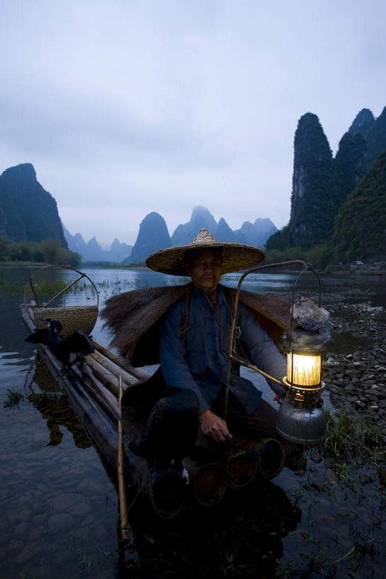 东方人,一个人,渔夫,蹲,竖图,室外,白天,正面,旅游,度假,日出,河流,美景,山,山脉,水,太阳,植物,鸟,帽子,照明,桂林,中国,亚洲,仅一个男性,仅一个人,一排,一艘,握,阴影,竹制,整齐,编织,光线,鸬鹚,鸟类,船桨,影子,竹排,河水,景观,山峰,水流,灯光,运输工具,朝霞,晨曦,黎明,山峦,背光,拿,拿着,黄种人,娱乐,捕鱼,煤油灯,竹筏,灯,斗笠,树,树木,排列,仅一个年轻男性,衣服,蓝色,绿色,倒影,阳光,自然,灯具,交通工具,群山,两只,享受,休闲,遮阳,景色,放松,握着,生长,成长,广西,竹条,照亮,倒映,竹制品,照明设备,队列,自然风光,载具,逆光,鱼鹰,水老鸦,东亚,蓑衣,漓江,阳朔,广西壮族自治区,中华人民共和国,桂林市,桂,华南地区,反照,水上交通工具,笠帽,阳朔县,兴坪,兴坪镇,男人,男性,年轻男性,亚洲人,捕鱼人,打鱼人,朝阳,蹲着,彩图,全身,卯时,破晓,日始,编结帽,箬笠,蔽雨,马灯