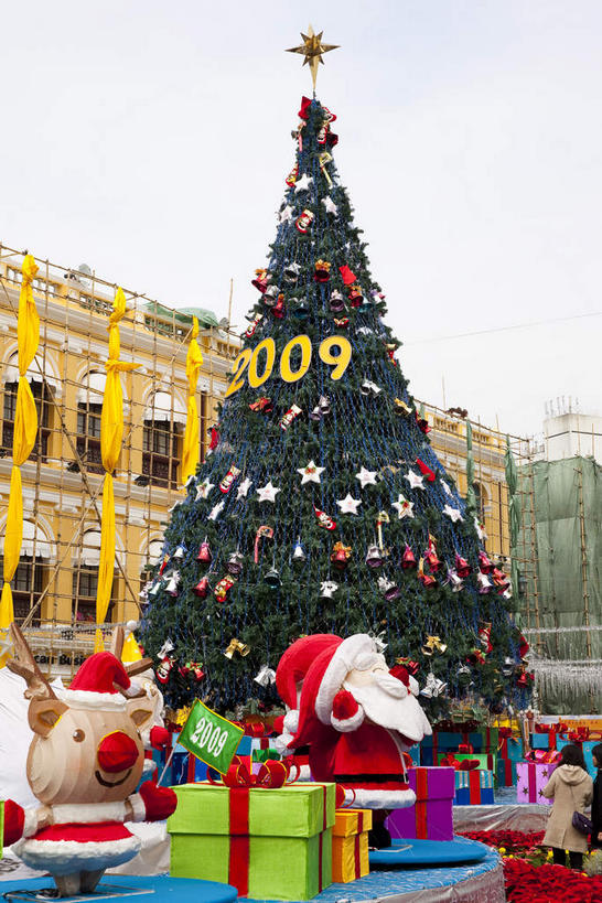 无人,广场,竖图,室外,白天,正面,旅游,度假,植物,标志建筑,地标,建筑,礼盒,礼物,照明,澳门,中国,亚洲,阴影,光线,标志,彩灯,数字,丝绸,丝带,文字,影子,纸盒,字符,灯光,圣诞树,缎带,娱乐,标识,建设,绸带,灯,盒子,树,树木,蓝色,绿色,蓝天,天空,阳光,自然,包装盒,礼品盒,灯具,天,享受,休闲,旅游胜地,放松,阿拉伯数字,花灯,礼品,生长,晴朗,成长,照亮,照明设备,东亚,万里无云,港澳台,中华人民共和国,澳门特别行政区,澳,晴空,晴空万里,彩图,议事亭前地