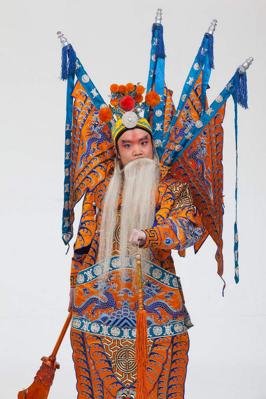 东方人,胡须,一个人,演员,站,竖图,室内,白天,白色背景,正面,民族服装,化妆,竞争,旗帜,亚洲,仅一个男性,仅一个人,仅一个中年男性,一把,对抗,握,服装,冲突,头饰,注视,黄种人,破坏,文化,旗子,衣服,白色,彩妆,发夹,发饰,夹子,观察,看,站着,橙色,大衣,武器,战争,握着,摄影,服饰,影棚,观看,损坏,察看,攻击,威胁,衣着,穿着,对立,关注,矛盾,中国文化,摄影棚,兵器,防御,表演服,演出服,京剧,将军,戏曲,国粹,皮黄,敌对,挫败,斗争,抗拒,抗衡,杀伤,威慑,旌旗,旗号,衣饰,将领,道具服,危险,男人,男性,中年男性,亚洲人,胡子,络腮胡,站立,半身,彩图,影棚拍摄,传统服装,民俗服,拍摄,京剧服饰,国剧,京戏,平剧,中国戏曲,传统文化,关内侯,后将军,汉升,黄忠,舞台妆,京剧演员