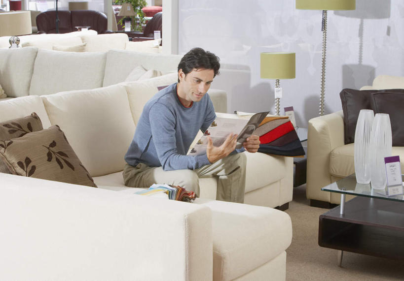 西方人,一个人,商店,坐,笑,微笑,横图,室内,白天,正面,阅读,靠垫,沙发,桌子,照明,欧洲,欧洲人,仅一个男性,仅一个人,仅一个中年男性,握,服装,木制,灯光,靠枕,拿,茶几,拿着,注视,休闲装,商铺,灯,衣服,木制品,灯具,垫子,落地灯,枕头,观察,看,休闲,休闲服,浏览,握着,服饰,皮夹子,钱包,观看,照亮,察看,册子,零钱包,照明设备,皮夹,关注,宣传,布艺沙发,宣传册,美观,市肆,商号,男人,男性,中年男性,白种人,坐着,半身,彩图,店铺,家居店,家居生活馆,家具店,居家生活馆