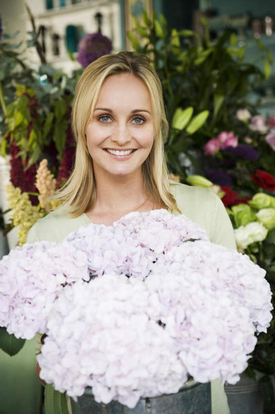 西方人,一个人,花商,站,捧,笑,微笑,露齿笑,竖图,室内,白天,正面,骄傲,窗户,八仙花,欧洲,欧洲人,仅一个年轻女性,仅一个女性,仅一个人,许多,服装,朦胧,模糊,盛开,花蕾,注视,休闲装,玻璃窗,花,花瓣,花朵,鲜花,衣服,花苞,花蕊,绣球花,观察,看,站着,休闲,休闲服,金色,服饰,观看,紫阳花,洋绣球,察看,关注,草绣球,斗球,七变化,粉团花,善变,年轻女性,女人,女性,白种人,长发,花店老板,花贩,卖花人,端,端着,捧着,手捧,站立,半身,彩图