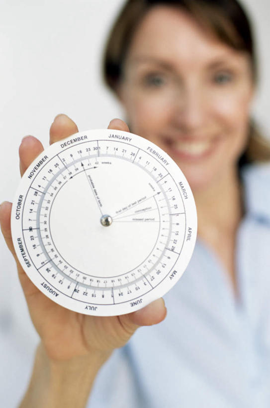 西方人,站,举,笑,微笑,露齿笑,竖图,室内,白天,正面,欧洲,欧洲人,握,时间,英文,标志,文字,字符,字母,拿,计时,拿着,注视,标识,转盘,观察,看,托,站着,握着,观看,英文字母,日期,察看,关注,白种人,日历,举起,举手,举着,向上举,向上伸,向上托,站立,半身,彩图,万年历