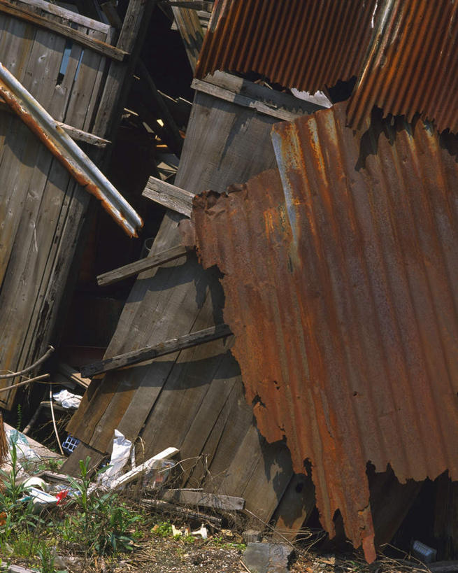 无人,竖图,室外,白天,正面,草地,草坪,植物,静物,一堆,许多,阴影,堆叠,堆积,环保,生锈,光线,木板,木条,木头,影子,泥土,褐色,垃圾,草,绿色,阳光,堆,废铁,回收,资源,利用,低碳,循环,彩图