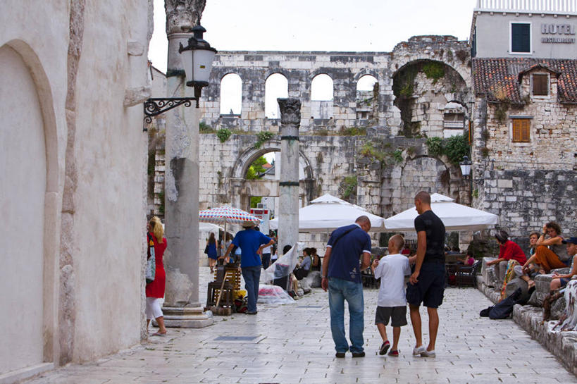 西方人,站,坐,走,横图,室外,白天,正面,旅游,度假,标志建筑,道路,地标,建筑,路,公路,欧洲,克罗地亚,欧洲人,行人,游客,游人,阴影,服装,光线,伞,影子,雨伞,遮阳伞,墙,拱门,交通,许多人,注视,休闲装,娱乐,阳伞,建设,路人,旅客,墙壁,墙面,衣服,阳光,观察,看,站着,一群人,享受,休闲,休闲服,旅游胜地,放松,服饰,观看,察看,太阳伞,关注,首府,克罗地亚共和国,过客,斯普利特,戴克里先宫,斯普利特.达尔马提亚县,男人,男性,年轻男性,年轻女性,女人,女性,中年男性,中年女性,白种人,马路,步行,散步,站立,走路,坐着,彩图,全身,斯普利特.达尔马提亚