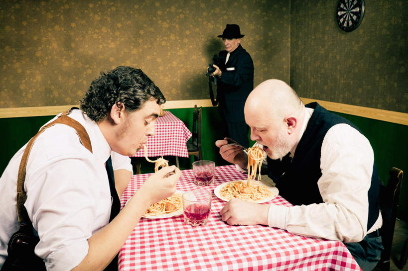 意大利面,葡萄酒,西方人,手,三个人,站,坐,吃,横图,俯视,室内,白天,绘画,餐桌,桌子,帽子,椅子,欧洲,欧洲人,握,服装,艺术,装饰,枪,木椅,墙,酒类,两杯,拿,拿着,注视,休闲装,礼帽,文化,壁画,墙壁,墙面,酒,饮料,衣服,观察,看,站着,休闲,手部,休闲服,握着,服饰,餐台,观看,华丽,修饰,点缀,察看,关注,衬托,美观,雅致,雅观,两盘,男人,男性,中年男性,白种人,画画,嚼,食,站立,坐着,半身,彩图,高角度拍摄