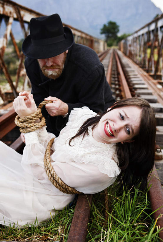 西方人,两个人,栏杆,竖图,室外,白天,正面,草地,草坪,山,山脉,树林,植物,路,铁路,帽子,欧洲,欧洲人,阴影,光线,影子,栅栏,篱笆,山峰,围栏,轨道,交通,铁轨,山峦,礼帽,护栏,草,树,树木,蓝色,绿色,蓝天,天空,阳光,自然,群山,天,运输,生长,成长,捆绑,绑架,虐待,谋杀,绑缚,男人,男性,年轻男性,年轻女性,女人,女性,白种人,半身,彩图