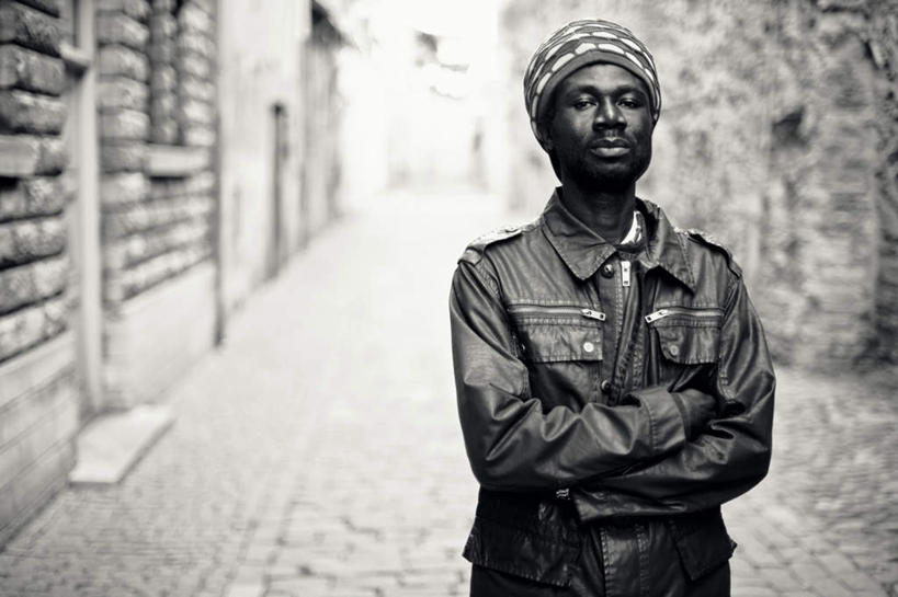 西方人,一个人,站,双手交叉,横图,黑白,室外,白天,正面,道路,路,欧洲,非洲,黑人,欧洲人,仅一个男性,仅一个人,仅一个中年男性,头巾,墙,小路,小巷,交通,注视,墙壁,墙面,观察,看,站着,观看,察看,双手抱胸,关注,冷巷,男人,男性,中年男性,非洲人,站立,半身