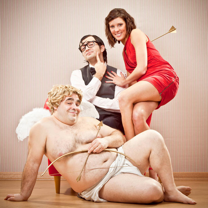 西方人,肥胖,三个人,坐,躺,笑,微笑,露齿笑,方图,室内,白天,正面,裙子,西装,爱情,地板,欧洲,欧洲人,撑,握,指,阴影,条纹,连衣裙,套装,正装,神话,装饰,反射,翅膀,弓箭,领结,眼镜,影子,墙,地面,浪漫,二郎腿,注视,指点,职业装,光脚,文化,裸露,木地板,墙壁,墙面,黄色,红色,观察,看,温暖,温馨,赤脚,恩爱,搭,握着,恋人,赤裸,观看,华丽,修饰,点缀,和睦,察看,撑着,指向,象征,庄重,搭着,关注,裸,传说,身份,丘比特,近视眼镜,希腊神话,衬托,美观,雅致,雅观,正式,地位,肥,胖,小爱神,爱罗斯,卧着,男人,男性,年轻男性,年轻女性,女人,女性,白种人,情侣,躺着,卧,坐着,彩图,全身,伴侣,融洽