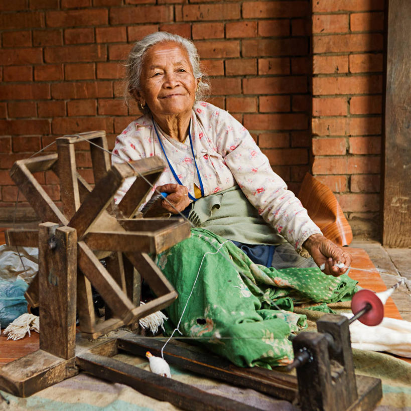 西方人,一个人,坐,笑,微笑,横图,室外,白天,正面,机器,建材,建筑,欧洲,欧洲人,仅一个女性,仅一个人,握,服装,材料,砖,砖块,墙,拿,拿着,扭头,注视,休闲装,墙壁,墙面,装饰品,衣服,耳环,饰品,首饰,观察,看,转头,休闲,休闲服,机械,砖头,搭,握着,建造,服饰,纺织机,仅一个老年女性,观看,察看,搭着,关注,耳饰,老年女性,女人,女性,白种人,石料,抬头,仰头,坐着,彩图,全身,砌墙砖