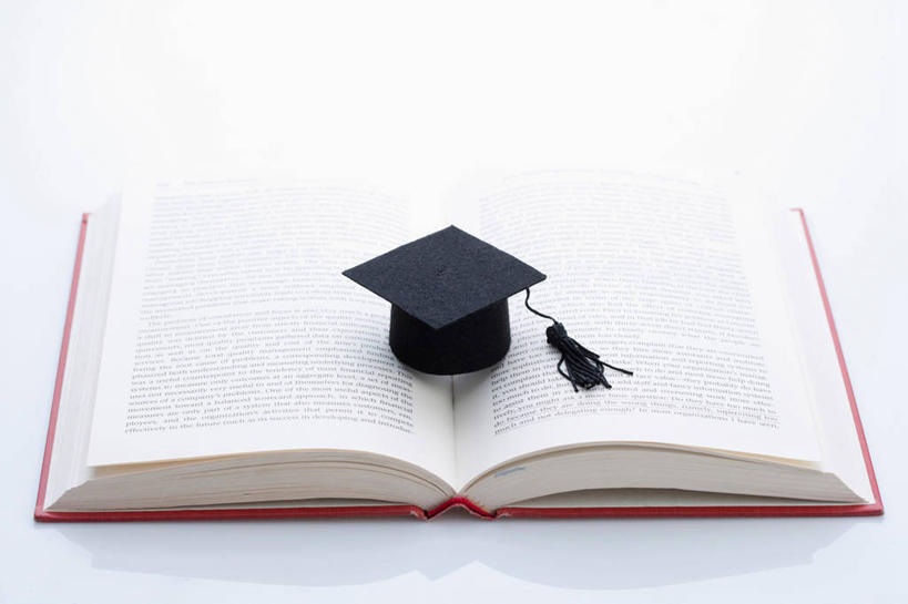 无人,横图,俯视,室内,特写,白天,白色背景,桌子,静物,帽子,书籍,一本,阴影,反射,影子,书桌,红色,白色,黑色,课桌,书本,打开,翻开,摄影,影棚,博士帽,一顶,学位帽,掀开,书,图书,彩图,高角度拍摄,影棚拍摄,拍摄