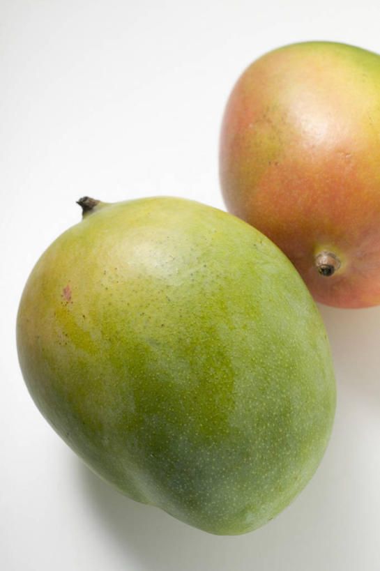 无人,竖图,俯视,室内,特写,白天,白色背景,餐桌,桌子,芒果,水果,阴影,新鲜,反射,影子,生食,食品,果实,食物,两个,摄影,有机食品,绿色食品,影棚,餐台,望果,蜜望,檬果,闷果,漭果,杧果,庵波罗果,彩图,高角度拍摄,影棚拍摄,拍摄