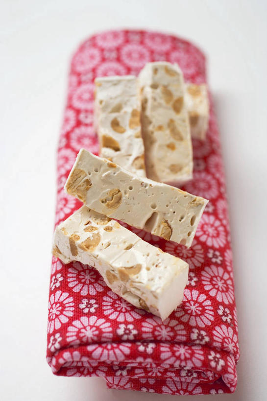 无人,竖图,俯视,室内,特写,白天,白色背景,餐桌,桌子,杏仁,阴影,反射,影子,食品,糖,糖果,甜点,甜品,食物,粉色,餐巾,甜食,摄影,影棚,餐台,牛轧糖,鸟结糖,纽结糖,保洁方巾,口布,杏子,杏梅仁,杏核仁,木落子,苦杏仁,彩图,高角度拍摄,影棚拍摄,拍摄