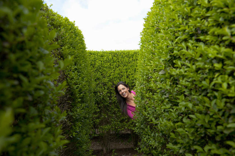 西方人,一个人,站,笑,微笑,露齿笑,横图,室外,白天,正面,游戏,植物,欧洲,欧洲人,仅一个年轻女性,仅一个女性,仅一个人,阴影,服装,环保,光线,影子,防护,玩,注视,休闲装,娱乐,树,树木,衣服,蓝色,绿色,蓝天,天空,阳光,自然,天,观察,看,站着,休闲,休闲服,服饰,生长,晴朗,成长,观看,活动,察看,捉迷藏,发泄,关注,美好,美妙,消遣,智力,间隔,躲猫猫,万里无云,宣泄,美观,雅观,绿篱,生篱,树篱,植篱,年轻女性,女人,女性,白种人,晴空,晴空万里,玩耍,嬉戏,站立,半身,彩图