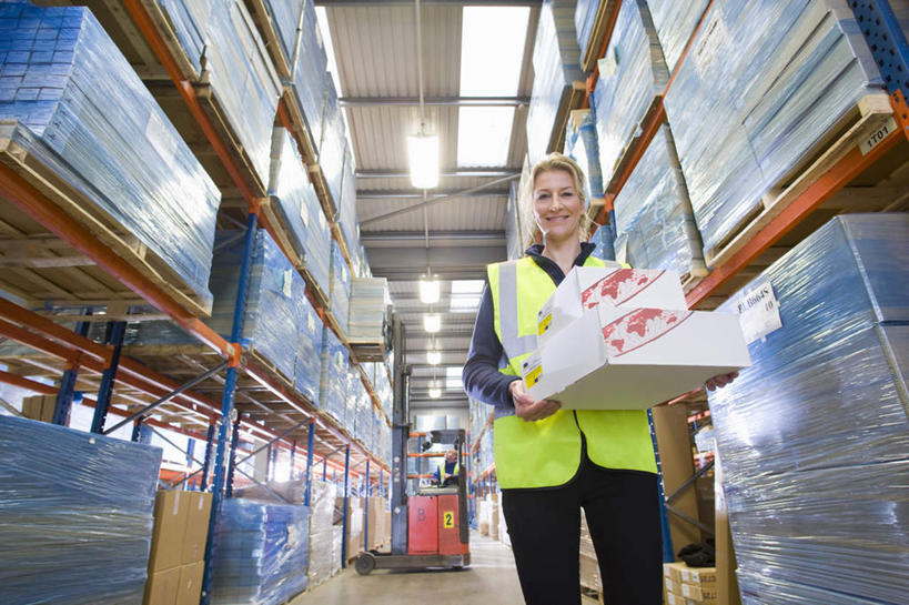 西方人,一个人,站,捧,笑,微笑,露齿笑,横图,室内,白天,仰视,工作服,制服,天花板,照明,欧洲,欧洲人,仅一个女性,仅一个人,纸盒,灯光,仓库,注视,顶灯,货架,架子,灯,盒子,包装盒,容器,灯具,观察,看,站着,仅一个中年女性,观看,储藏,照亮,固定,察看,照明设备,储存,关注,陈列架,工作制服,女人,女性,中年女性,白种人,端,端着,捧着,手捧,站立,半身,彩图,低角度拍摄,工作套服,安全服,反光背心,反光服,反光衣,货盘,贮存