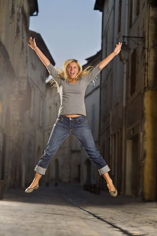 西方人,一个人,家,跳,伸展双臂,笑,微笑,露齿笑,竖图,室外,白天,正面,窗户,道路,路,公路,欧洲,欧洲人,仅一个年轻女性,仅一个女性,仅一个人,阴影,服装,裤子,光线,影子,房屋,墙,屋子,交通,注视,牛仔裤,休闲装,楼房,玻璃窗,墙壁,墙面,住宅,衣服,蓝色,蓝天,天空,阳光,天,观察,看,休闲,休闲服,服饰,晴朗,观看,张开双腿,察看,关注,万里无云,展开双腿,年轻女性,女人,女性,白种人,晴空,晴空万里,马路,敞开双臂,伸开双臂,跳跃,展开双肩,张开手臂,张开双臂,彩图,全身,房子,伸展双腿