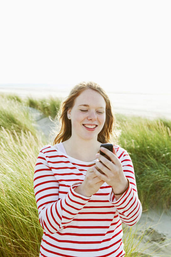 西方人,一个人,站,笑,打电话,微笑,露齿笑,竖图,室外,白天,正面,草地,沙滩,植物,电话,手机,欧洲,欧洲人,仅一个年轻女性,仅一个女性,仅一个人,握,阴影,服装,光线,沙子,影子,海岸,沙地,拿,拿着,注视,休闲装,通讯设备,装饰品,草,一个,衣服,绿色,阳光,饰品,手链,首饰,观察,看,站着,休闲,休闲服,握着,服饰,手镯,单个,观看,察看,关注,镯子,交流,年轻女性,女人,女性,白种人,海滩,沟通,通话,站立,半身,彩图