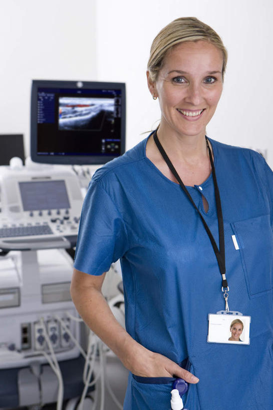 西方人,一个人,医生,护士,医院,站,笑,微笑,露齿笑,竖图,照片,室内,白天,正面,欧洲,欧洲人,仅一个女性,仅一个人,检查,医学,注视,标识,吊牌,胸牌,观察,看,站着,仅一个中年女性,医护人员,医疗人员,摄影,观看,察看,检测,医疗设备,徽章,白衣天使,关注,B超,红外线,医疗器械,身份,手插袋,单手插袋,胸章,医疗机构,胸卡,单手抄兜,单手放兜,编号牌,雕刻牌,工号牌,胸号牌,胸徽,员工牌,女人,女性,中年女性,白种人,大夫,相片,插兜,手插兜,手放口袋,站立,半身,彩图,拍摄,照相,病院,诊所,手抄兜