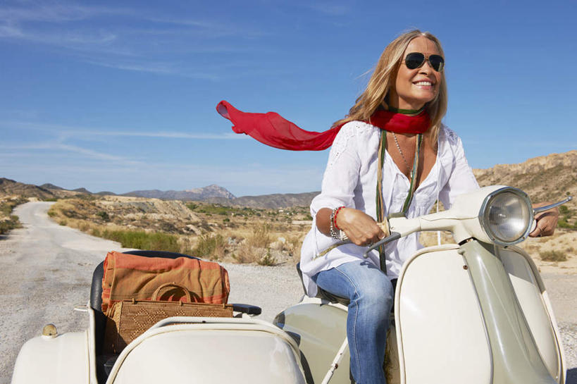 西方人,一个人,坐,笑,微笑,露齿笑,横图,室外,白天,正面,沙漠,山,植物,道路,路,公路,摩托车,项链,欧洲,欧洲人,仅一个女性,仅一个人,一辆,握,阴影,服装,枯萎,装饰,光线,墨镜,丝巾,眼镜,影子,山峰,云,云朵,枯草,交通,山峦,云彩,注视,休闲装,车,装饰品,草,衣服,黄色,蓝色,白云,蓝天,天空,阳光,饰品,首饰,太阳镜,太阳眼镜,交通工具,天,观察,驾驶,开车,看,行驶,仅一个中年女性,休闲,休闲服,橙色,遮阳镜,握着,服饰,晴朗,观看,操纵,华丽,点缀,控制,察看,关注,载具,操控,衬托,美观,雅致,雅观,把持,女人,女性,中年女性,白种人,大漠,砂漠,晴空,马路,坐着,半身,彩图