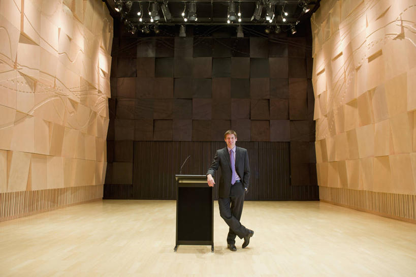 西方人,一个人,商务人士,商务男性,舞台,站,横图,室内,白天,正面,鞋,衬衫,鞋子,欧洲,欧洲人,仅一个男性,仅一个人,阴影,套装,光线,影子,墙,灯光,领带,皮革,注视,墙壁,墙面,仅一个年轻男性,话筒,讲台,观察,看,站着,搭,观看,察看,麦克风,象征,庄重,搭着,关注,扩音器,演说台,商务装,身份,手插袋,单手插袋,传声器,工薪阶层,演讲台,单手抄兜,单手放兜,正式,地位,微音器,男人,男性,年轻男性,白种人,白领,上班族,表演台,插兜,手插兜,手放口袋,站立,彩图,全身,衬衣,皮鞋,手抄兜