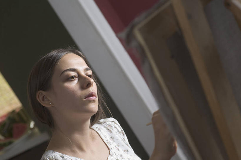 西方人,一个人,坐,横图,室内,白天,侧面,绘画,欧洲,欧洲人,仅一个女性,仅一个人,握,阴影,服装,朦胧,模糊,艺术,反射,影子,画板,美术用品,拿,拿着,注视,休闲装,画架,衣服,观察,看,仅一个中年女性,休闲,休闲服,握着,服饰,观看,美术,察看,绘图,关注,绘画工具,女人,女性,中年女性,白种人,画画,画图,摹绘,坐着,半身,彩图