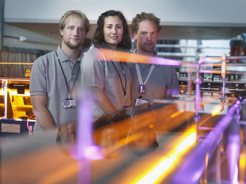 西方人,三个人,同事,科学家,站,笑,微笑,露齿笑,横图,室内,白天,正面,工作服,制服,成功,合作,团队,集体,信心,激光,照明,欧洲,欧洲人,一排,弯腰,阴影,朦胧,模糊,整齐,辐射,光线,影子,灯光,注视,标识,吊牌,队伍,灯,排列,黄色,紫色,灰色,胸牌,灯具,观察,看,站着,发电厂,发电站,观看,聚光灯,照亮,核电站,核能,察看,徽章,领导,科研人员,照明设备,成就,队列,关注,研究者,身份,合伙,领袖,镭射,胸章,胸卡,科学研究者,弯身,编号牌,雕刻牌,工号牌,胸号牌,胸徽,员工牌,工作制服,核电厂,男人,男性,年轻男性,年轻女性,女人,女性,白种人,科学工作者,站立,半身,彩图,工作套服,莱塞