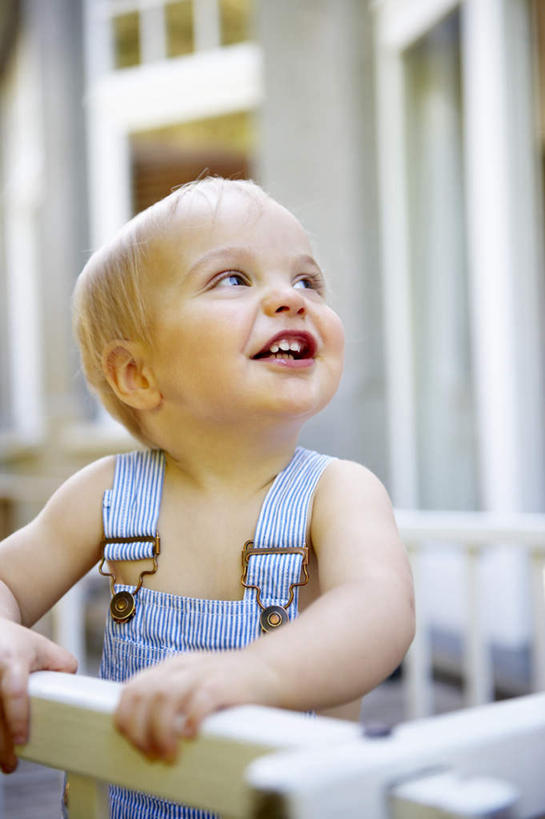 西方人,婴儿,儿童,头发,一个人,栏杆,站,笑,微笑,露齿笑,竖图,室外,白天,正面,纯洁,欧洲,欧洲人,仅一个人,握,裤子,朦胧,模糊,围栏,注视,护栏,小孩,蓝色,白色,看,站着,金色,背带裤,可爱,握着,活泼,关注,宝宝,纯真,烂漫,无邪,饭单裤,工装裤,伶俐,天真,白种人,孩子,抬头,仰头,站立,半身,彩图