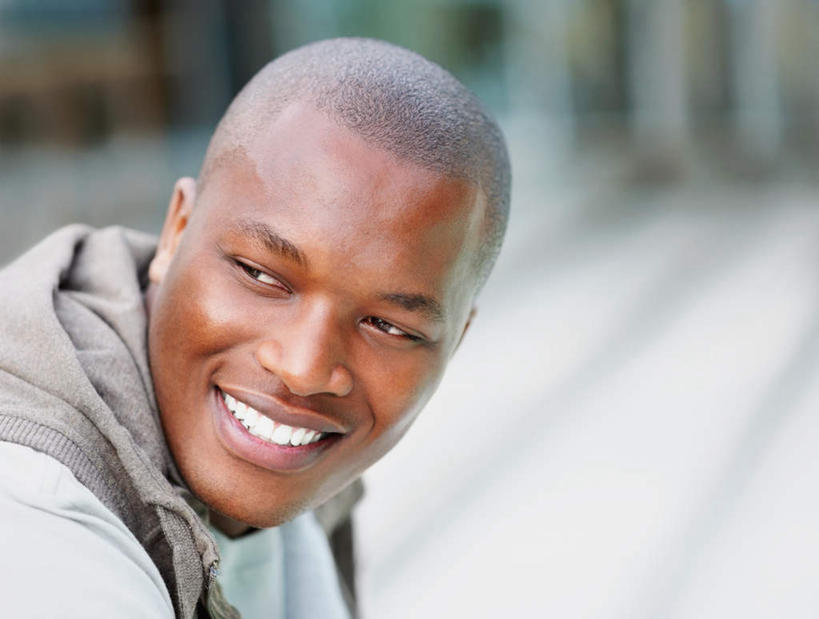 西方人,脸,头,脸颊,秃头,一个人,坐,笑,微笑,露齿笑,横图,室外,白天,侧面,欧洲,非洲,黑人,欧洲人,仅一个男性,仅一个人,阴影,服装,朦胧,模糊,光线,影子,地面,注视,休闲装,肩膀,仅一个年轻男性,衣服,阳光,观察,看,休闲,休闲服,连帽衫,服饰,观看,察看,关注,帽衫,男人,男性,年轻男性,非洲人,头部,光头,无发,脸部,脸蛋,面部,坐着,半身,彩图