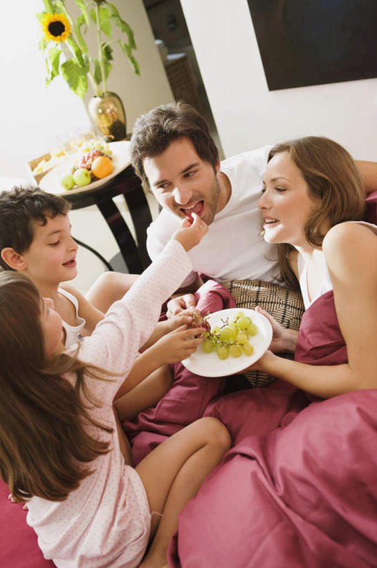 西方人,儿童,四个人,家庭,夫妻,母亲,父亲,女儿,儿子,坐,笑,微笑,露齿笑,竖图,室内,白天,正面,爱情,纯洁,床,卧室,葡萄,餐具,水果,欧洲,欧洲人,许多,握,阴影,服装,新鲜,反射,碟子,盘,影子,墙,双人床,生食,食品,果实,床单,很多,浪漫,拿,拿着,注视,休闲装,被子,墙壁,墙面,食物,小孩,衣服,粉色,红色,白色,盘子,碟,低头,观察,看,休闲,温暖,温馨,父女,父子,母女,母子,一家人,休闲服,恩爱,父爱,可爱,母爱,童年,童趣,握着,恋人,服饰,有机食品,绿色食品,观看,和睦,察看,被单,关注,童真,烂漫,无邪,天真,男孩,男人,男性,年轻男性,年轻女性,女孩,女人,女性,白种人,孩子,年轻人,夫妇,情侣,山葫芦,蒲桃,草龙珠,坐着,半身,彩图,睡房,卧房,伴侣,融洽,男生,女生