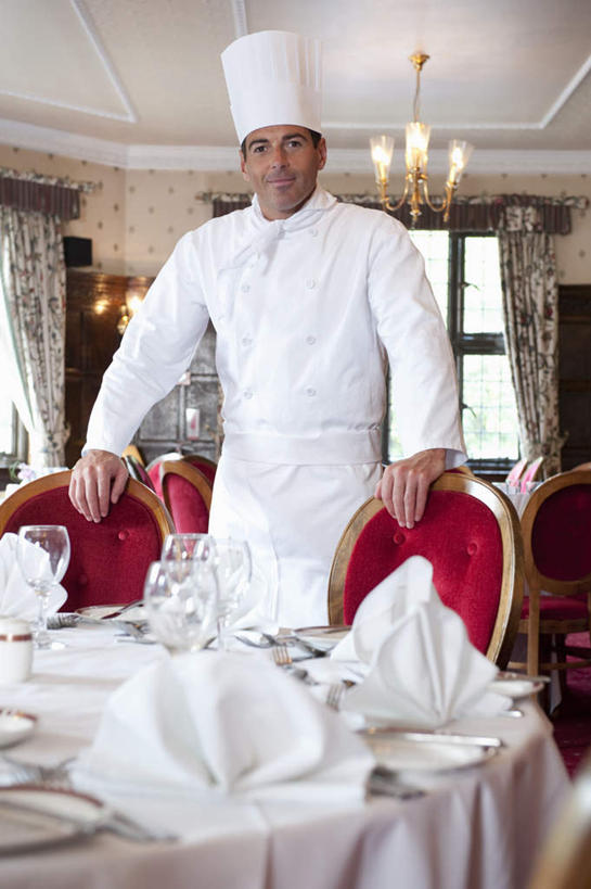 西方人,一个人,厨师,宾馆,站,笑,微笑,露齿笑,竖图,室内,白天,正面,工作服,制服,餐桌,窗户,天花板,桌子,酒店,帽子,椅子,照明,欧洲,欧洲人,仅一个男性,仅一个人,仅一个中年男性,许多,布料,灯光,折叠,布纹,注视,吊灯,玻璃窗,灯,桌布,排列,红色,白色,餐巾,灯具,台布,扶,观察,看,站着,餐台,观看,照亮,察看,扶着,照明设备,队列,关注,厨师帽,工作制服,保洁方巾,口布,男人,男性,中年男性,白种人,厨师长,厨子,大厨,主厨,站立,半身,彩图,工作套服,客店,客栈,旅店,旅馆,旅舍,汽车旅馆