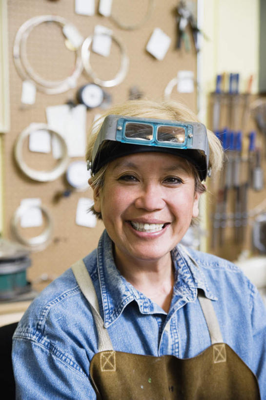 西方人,脸,头,脸颊,一个人,工厂,站,笑,微笑,露齿笑,竖图,室内,特写,白天,正面,工作服,欧洲,欧洲人,仅一个女性,仅一个人,阴影,朦胧,模糊,光线,围裙,眼镜,影子,肩膀,工人,安全帽,测量仪,站着,仅一个中年女性,表,眼罩,防护眼罩,工作台,女人,女性,中年女性,白种人,头部,脸部,脸蛋,面部,半身,彩图