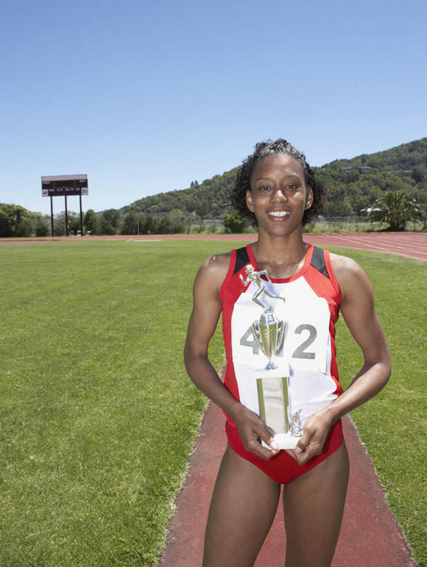 一个人,运动员,体育馆,运动场,起跑线,站,笑,微笑,露齿笑,竖图,室外,白天,正面,锻炼,快乐,比赛,运动,竞争,非洲,黑人,仅一个人,塑胶,田径,跑道,竞技场,训练,拿,拿着,注视,娱乐,运动器械,体育场,观察,看,站着,休闲,健康,体育用品,田径场,观看,察看,体育运动,关注,奖牌,健身器材,运动馆,体育,女人,女性,非洲人,站立,半身,彩图,健身,奖杯