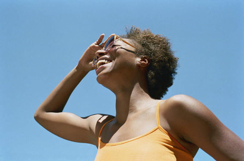 脸,头,脸颊,手,一个人,站,举,笑,微笑,露齿笑,横图,室外,特写,白天,仰视,旅游,度假,吊带,非洲,仅一个人,戴,眺望,遮住,阴影,服装,光线,背心,墨镜,眼镜,影子,注视,休闲装,娱乐,手叉腰,肩膀,衣服,蓝色,蓝天,天空,阳光,天,观察,看,站着,享受,休闲,休闲服,放松,服饰,晴朗,观看,戴着,察看,关注,万里无云,年轻女性,女人,女性,非洲人,头部,卷发,脸部,脸蛋,面部,晴空,晴空万里,举起,举着,抬头,仰头,站立,彩图,低角度拍摄