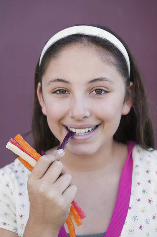 西方人,脸,头,脸颊,手,一个人,笑,吃,微笑,露齿笑,竖图,室内,特写,白天,正面,欧洲,欧洲人,仅一个年轻女性,仅一个女性,仅一个人,握,紫色背景,服装,装饰,头饰,食品,糖,糖果,甜点,甜品,拿,拿着,注视,休闲装,肩膀,食物,衣服,发箍,发饰,饰品,甜食,观察,看,休闲,手部,休闲服,握着,摄影,服饰,影棚,头箍,观看,单手,华丽,修饰,点缀,察看,关注,发卡,配饰,甘草糖,衬托,美观,雅致,雅观,年轻女性,女人,女性,白种人,头部,脸部,脸蛋,面部,嚼,食,半身,彩图,影棚拍摄,拍摄,盐甘草糖