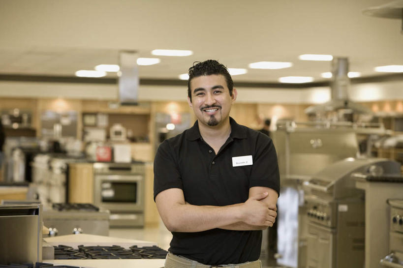 西方人,一个人,店员,商店,站,笑,双手交叉,微笑,露齿笑,横图,室内,白天,正面,照明,欧洲,欧洲人,仅一个男性,仅一个人,阴影,服装,朦胧,模糊,光线,影子,灯光,注视,休闲装,标识,吊牌,商铺,顶灯,灯,仅一个年轻男性,衣服,黑色,胸牌,灯具,观察,看,站着,营业员,休闲,休闲服,服饰,观看,照亮,察看,徽章,双手抱胸,照明设备,关注,身份,胸章,胸卡,编号牌,雕刻牌,工号牌,胸号牌,胸徽,员工牌,市肆,商号,销售人员,男人,男性,年轻男性,白种人,售货员,站立,半身,彩图,店铺,家居店,家居生活馆,家具店,居家生活馆