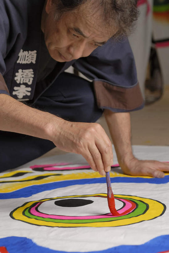 东方人,一个人,画家,跪,竖图,彩色,室内,白天,正面,工作服,制服,绘画,地板,旗帜,亚洲,仅一个男性,仅一个人,仅一个中年男性,撑,握,艺术,笔,鲤鱼旗,办公用品,地面,古典,拿,拿着,注视,黄种人,文化,旗子,木地板,文具,画笔,学习用品,工艺品,观察,看,品味,祈福,握着,观看,祈求,文具用品,美术,察看,撑着,高雅,关注,美学,旌旗,旗号,工作制服,鲤帜,男人,男性,中年男性,亚洲人,跪着,半身,彩图,工作套服