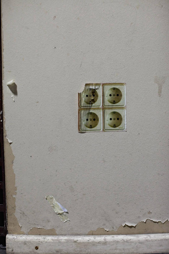 无人,竖图,室内,白天,正面,阴影,反射,电器,影子,墙,插座,破坏,破损,墙壁,墙面,米色,损坏,家用电器,插线板,拖线板,电源转换器,排插,彩图