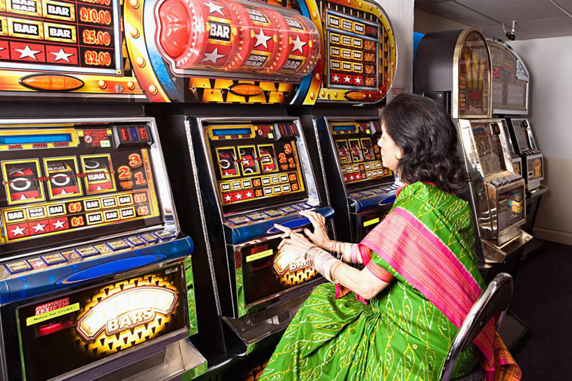 一个人,坐,横图,室内,白天,侧面,民族服装,游戏,赌博,贪欲,竞争,亚洲,仅一个女性,仅一个人,玩,注视,娱乐,刺激,观察,看,休闲,赌场,仅一个老年女性,观看,活动,察看,发泄,关注,消遣,智力,赌博机,赌具,老虎机,博彩,投机,侥幸,欲望,宣泄,柏青嫂,老年女性,女人,女性,亚洲人,印度人,玩耍,嬉戏,坐着,半身,彩图,传统服装,民俗服,胜负,输赢,娱乐场