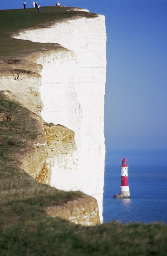 无人,竖图,室外,白天,正面,旅游,度假,草地,草坪,海浪,海洋,石头,美景,山,山脉,植物,道路,英国,欧洲,阴影,光线,信息,石子,影子,景观,浪花,山顶,山峰,水平线,悬崖,辽阔,灯塔,交通,海平线,山峦,方向,娱乐,英格兰,草,蓝色,绿色,蓝天,天空,阳光,自然,海水,群山,天,享受,休闲,广阔,景色,放松,晴朗,引导,指引,一望无际,西欧,自然风光,大不列颠,海景,沉积岩,大不列颠及北爱尔兰联合王国,万里无云,绝壁,大不列颠联合王国,日不落英帝国,航标,无边无际,一马平川,颠峰,极峰,萨塞克斯,萨塞克斯郡,苏塞克斯,水成岩,西萨塞克斯郡,大海,风浪,海,海水的波动,近岸浪,石块,岩石,涌浪,晴空,晴空万里,彩图,水天相接,水天一线,导航