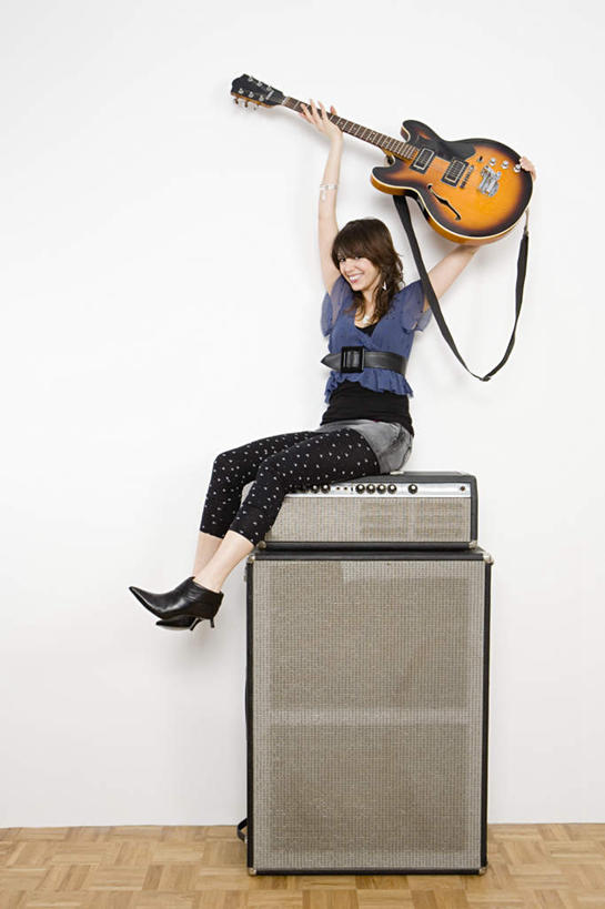 西方人,一个人,坐,举,竖图,室内,白天,白色背景,正面,地板,欧洲,欧洲人,仅一个年轻女性,仅一个女性,仅一个人,握,服装,墙,吉他,乐器,弦乐器,地面,拿,拿着,注视,休闲装,木地板,墙壁,墙面,衣服,观察,看,托,休闲,休闲服,握着,摄影,服饰,影棚,观看,察看,录音棚,录音室,关注,扩音器,弹拨弦鸣乐器,年轻女性,女人,女性,白种人,举起,举手,举着,向上举,向上伸,向上托,坐着,彩图,全身,影棚拍摄,拍摄,弹拨弦乐器