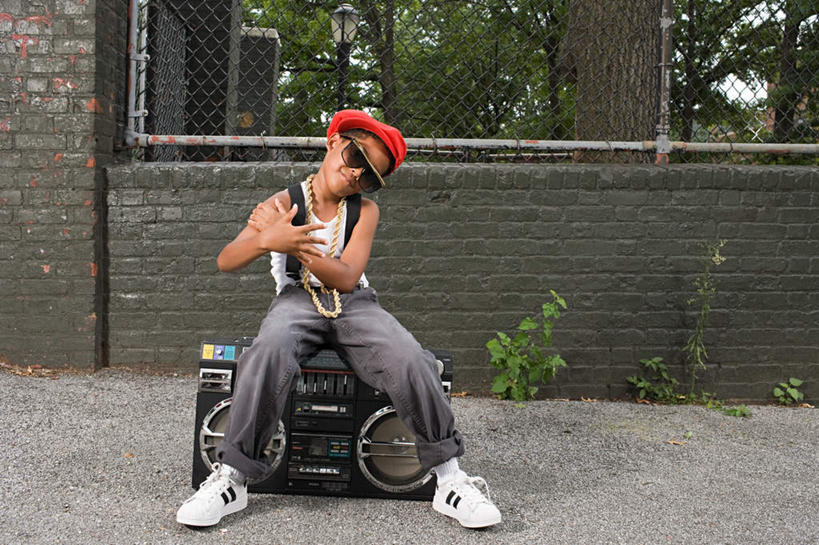 西方人,儿童,一个人,伙伴,朋友,坐,双手交叉,横图,室外,白天,正面,友谊,纯洁,植物,欧洲,非洲,黑人,欧洲人,仅一个男性,仅一个人,一副,服装,墨镜,束发带,眼镜,墙,铁丝网,音箱,注视,休闲装,墙壁,墙面,树,树木,小孩,衣服,绿色,自然,太阳镜,太阳眼镜,观察,看,仅一个小孩,休闲,休闲服,遮阳镜,可爱,童年,童趣,服饰,生长,成长,观看,察看,双手抱胸,关注,童真,烂漫,无邪,铁蒺藜,天真,友情,男孩,男人,男性,白种人,非洲人,孩子,坐着,彩图,全身,男生