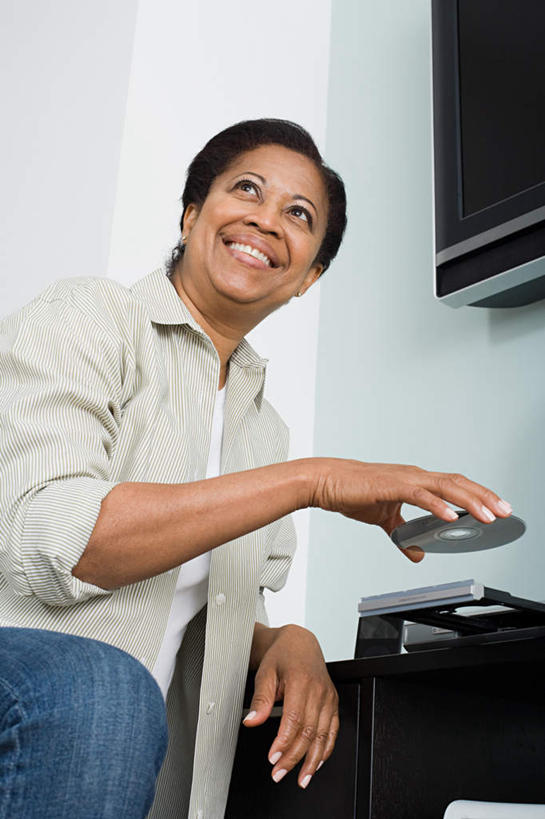 西方人,一个人,站,笑,微笑,露齿笑,竖图,室内,白天,仰视,数据,电视,欧洲,非洲,黑人,欧洲人,仅一个女性,仅一个人,握,服装,信息,光盘,墙,光碟,拿,拿着,注视,休闲装,存储介质,墙壁,墙面,衣服,观察,看,站着,仅一个中年女性,休闲,休闲服,握着,服饰,观看,碟片,存储,察看,影碟机,关注,DVD播放器,彩电,彩色电视机,显像管屏,显像管屏幕,DVD播放机,DVD影碟机,光盘存储器,数字多功能光盘,女人,女性,中年女性,非洲人,电视机,站立,半身,彩图,低角度拍摄