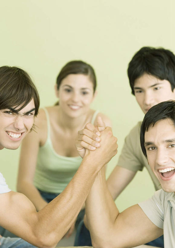 西方人,四个人,伙伴,朋友,握手,笑,微笑,露齿笑,竖图,室内,白天,正面,游戏,友谊,欧洲,欧洲人,墙,玩,注视,娱乐,墙壁,墙面,观察,看,张嘴,休闲,扳手腕,观看,察看,关注,张大嘴巴,友情,男人,男性,年轻男性,年轻女性,女人,女性,白种人,张开嘴,搀手,拉手,手拉手,手握手,玩耍,嬉戏,半身,彩图