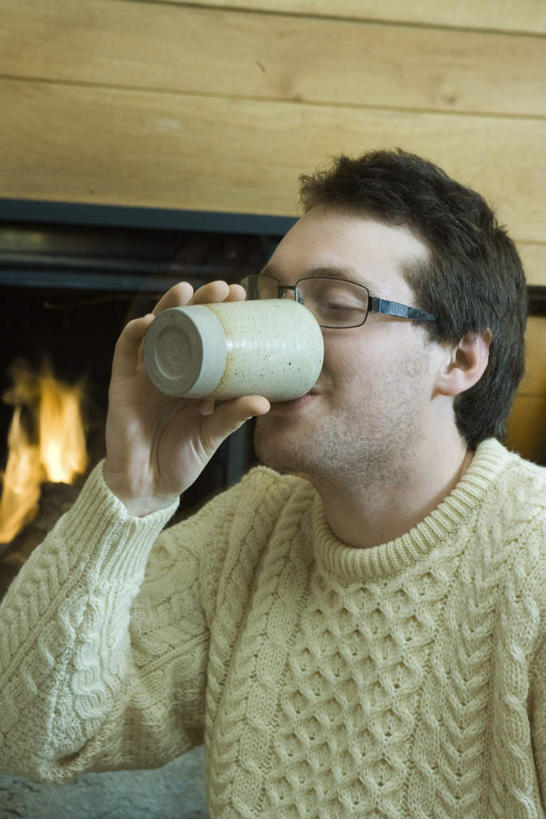 西方人,一个人,坐,笑,微笑,竖图,室内,白天,正面,毛衣,杯子,欧洲,欧洲人,仅一个男性,仅一个人,喝,握,火焰,炉火,墙,拿,拿着,墙壁,墙面,仅一个年轻男性,水杯,握着,男人,男性,年轻男性,白种人,茶杯,坐着,半身,彩图,绒衣,套衫,套头毛衣,线衣