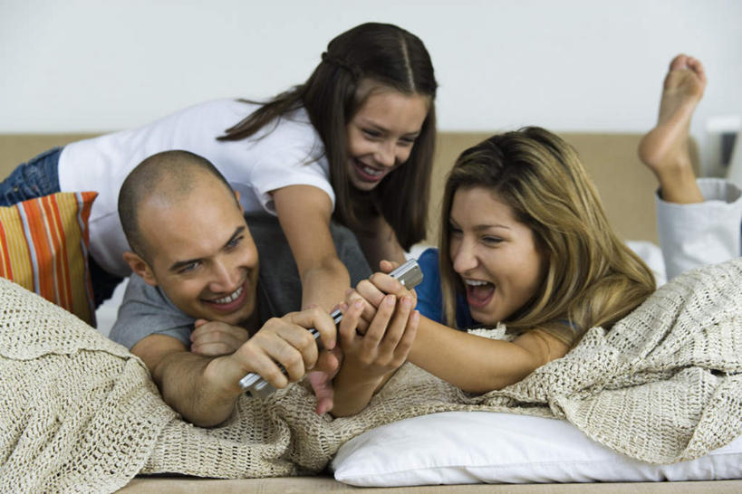 西方人,儿童,头发,三个人,家庭,夫妻,母亲,父亲,女儿,躺,笑,摸,微笑,露齿笑,横图,室内,白天,正面,爱情,游戏,纯洁,床,靠垫,卧室,欧洲,欧洲人,抚摸,抢,握,墙,床单,靠枕,浪漫,拿,玩,拿着,休闲装,娱乐,被子,墙壁,墙面,一个,小孩,黄色,白色,黑色,垫子,遥控器,枕头,趴着,张嘴,休闲,温暖,温馨,父女,母女,三口之家,一家人,休闲服,恩爱,父爱,可爱,母爱,童年,童趣,抬脚,握着,恋人,单人床,单个,活动,和睦,被单,发泄,消遣,智力,张大嘴巴,童真,烂漫,无邪,宣泄,卧着,天真,男人,男性,年轻男性,年轻女性,女孩,女人,女性,白种人,孩子,年轻人,情侣,张开嘴,触摸,接触,趴,躺着,玩耍,卧,嬉戏,半身,彩图,睡房,卧房,伴侣,融洽,女生