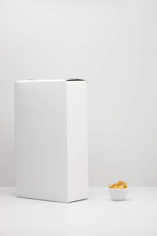 无人,竖图,室内,特写,白天,白色背景,正面,餐桌,桌子,静物,餐具,纸盒,盒子,包装盒,碗,摄影,影棚,餐台,麦片,五谷,进餐用具,烹调用具,彩图,影棚拍摄,拍摄