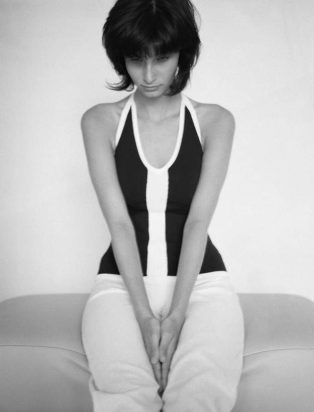 西方人,一个人,坐,竖图,黑白,室内,白天,白色背景,正面,沙发,欧洲,欧洲人,仅一个年轻女性,仅一个女性,仅一个人,服装,背心,休闲装,衣服,低头,双手合十,休闲,休闲服,摄影,服饰,影棚,布艺沙发,合十,年轻女性,女人,女性,白种人,坐着,半身,影棚拍摄,拍摄