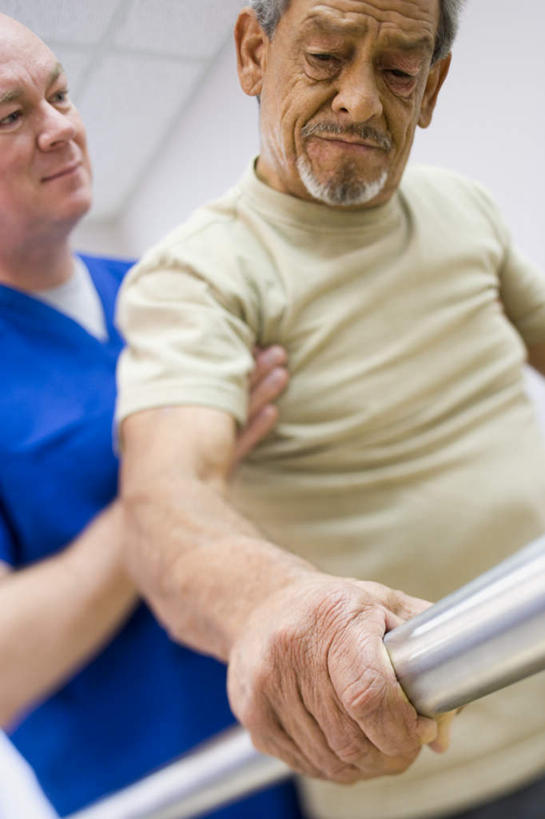 西方人,两个人,医生,病人,医院,站,笑,摸,微笑,竖图,室内,白天,仰视,欧洲,欧洲人,抚摸,服装,墙,注视,休闲装,运动器械,墙壁,墙面,衣服,扶,观察,看,站着,医护人员,医疗人员,休闲,休闲服,健身器械,扶持,服饰,观看,察看,搀扶,扶着,关注,病患,残疾,健身器材,残疾人,伤残,医疗机构,残障,弱势群体,老年男性,男人,男性,白种人,大夫,患者,就医者,触摸,接触,站立,半身,彩图,低角度拍摄,病院,诊所,运动器材